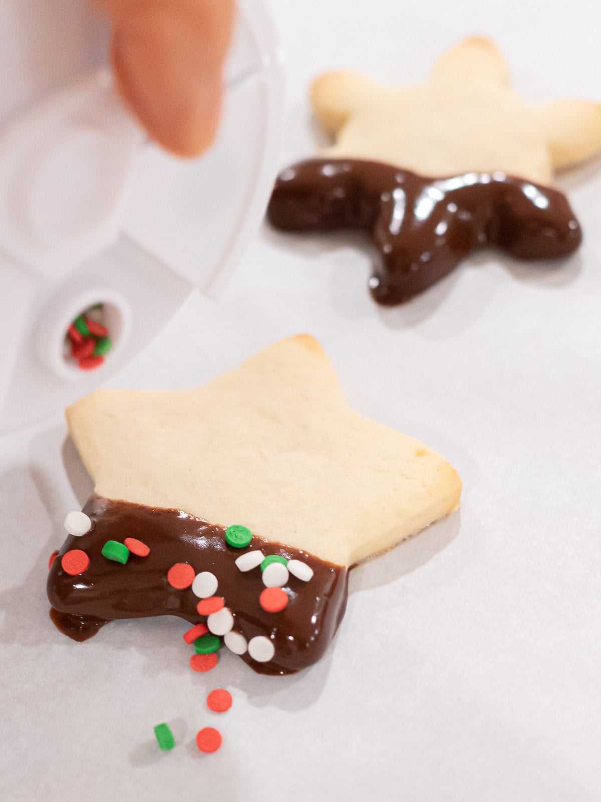 soft christmas sugar cookies dipped in chocolate and covered with sprinkles