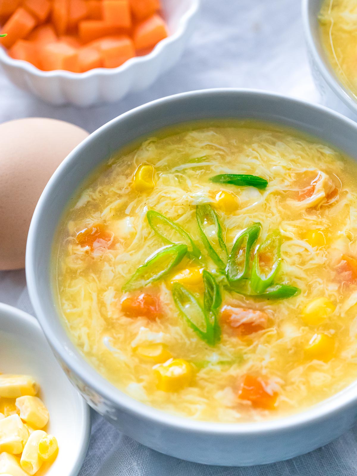 bowl of authentic egg drop soup with corn, carrots, and scallions