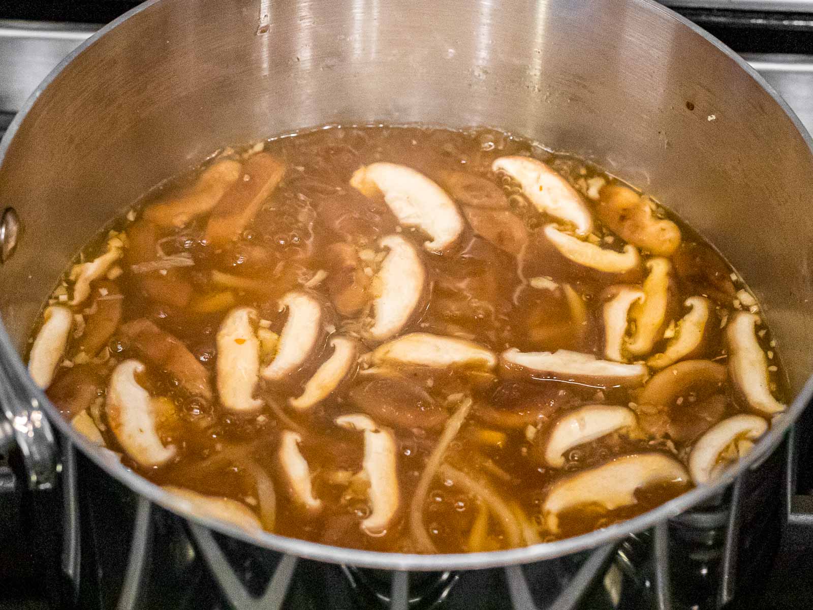 hot and sour soup in a pot with shiitake mushrooms