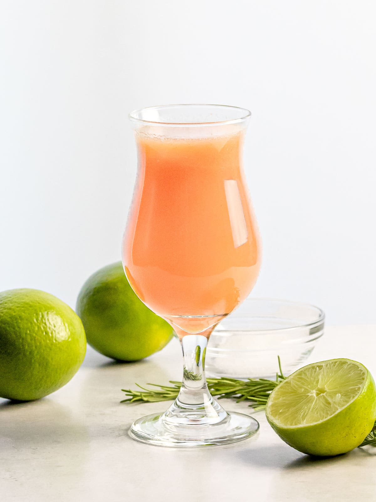 peach agua fresca in a glass next to limes