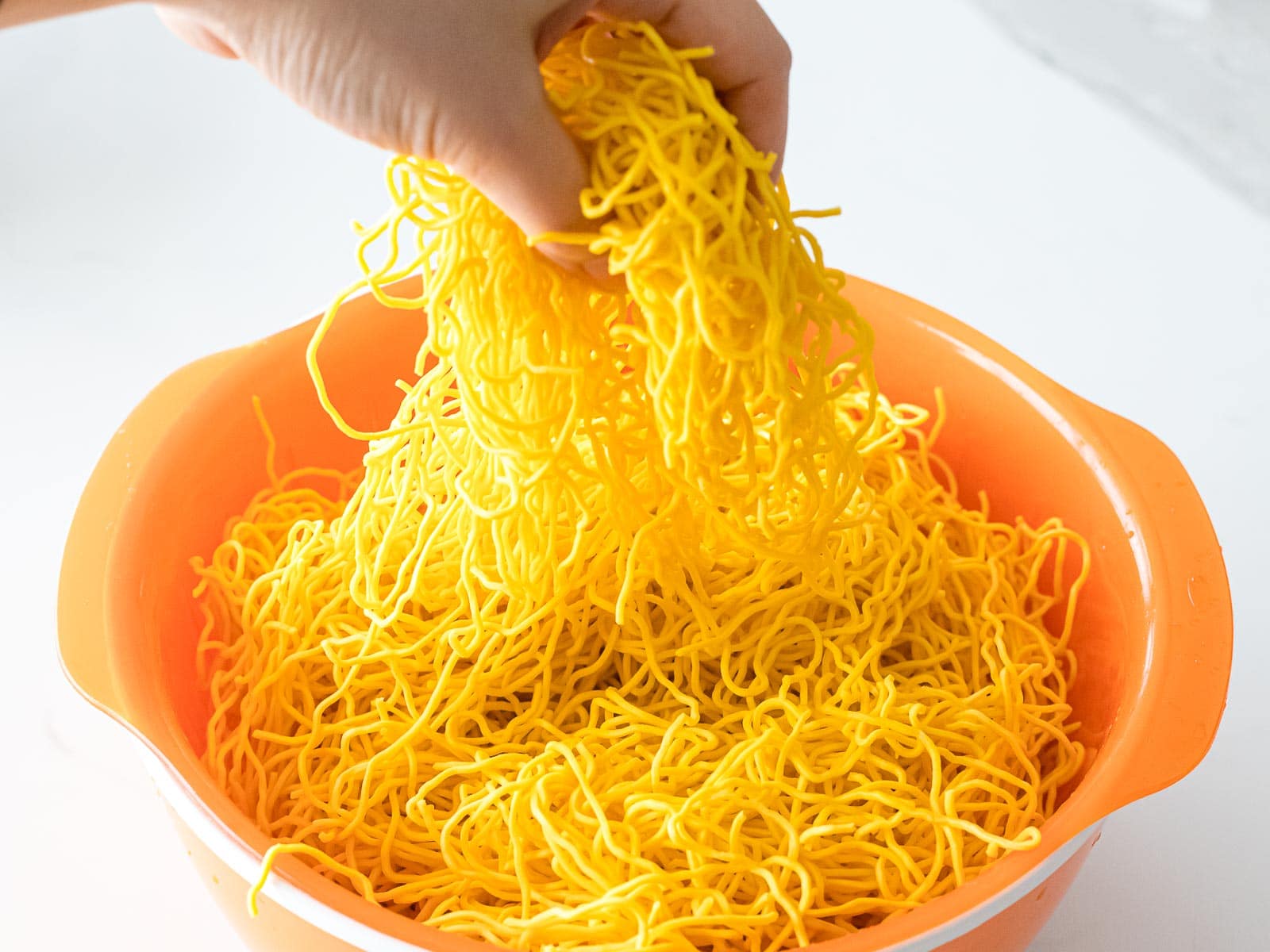 Chinese chow mein noodles in an orange bowl
