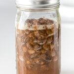 raisin yeast water with bubbles and foam in a glass mason jar with a lid