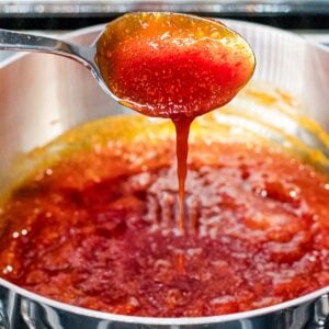 gochujang sauce boiling in a pot and dripping off of a spoon