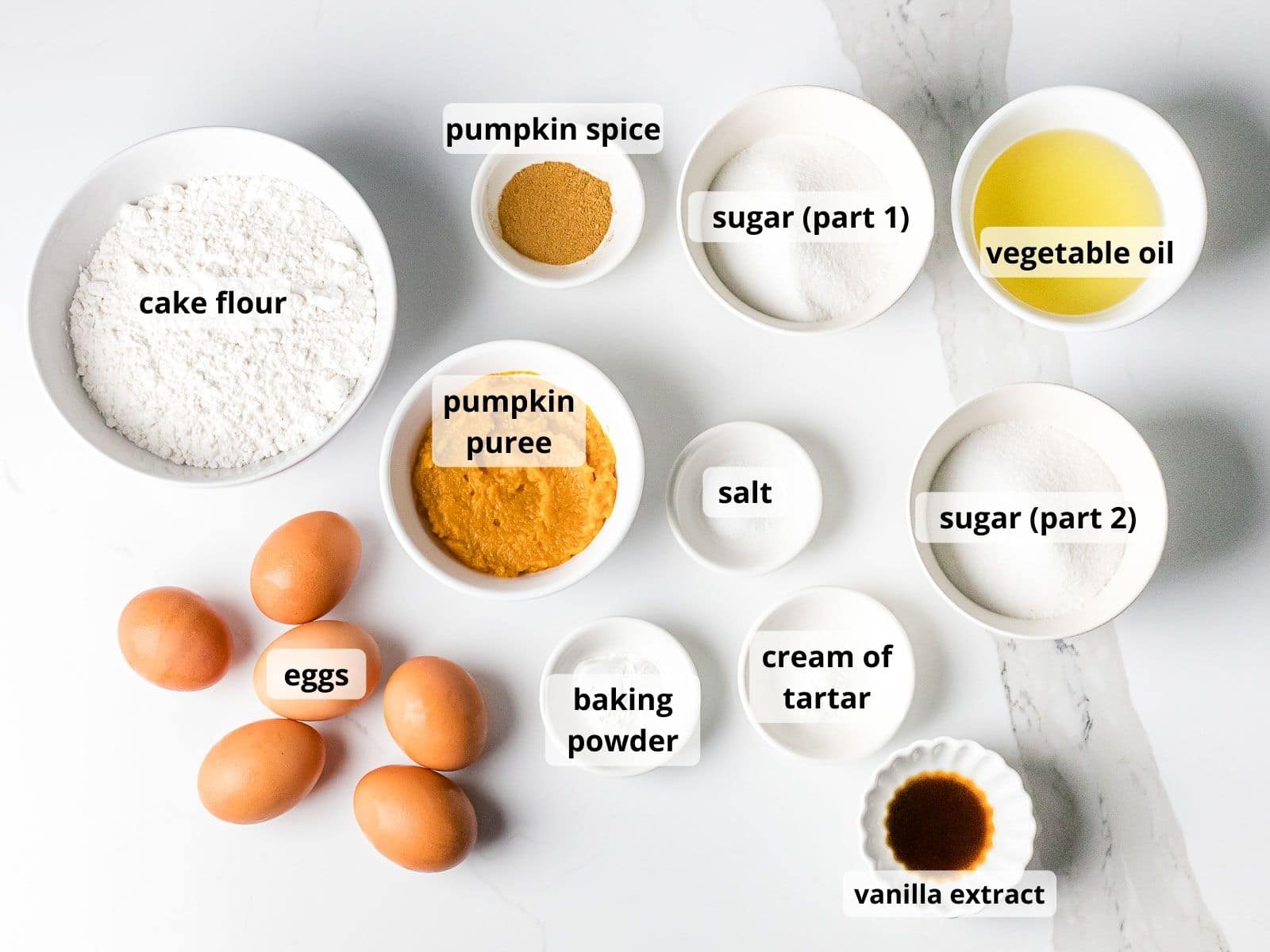 ingredients for pumpkin cake in little bowl with text overlay on top of each item