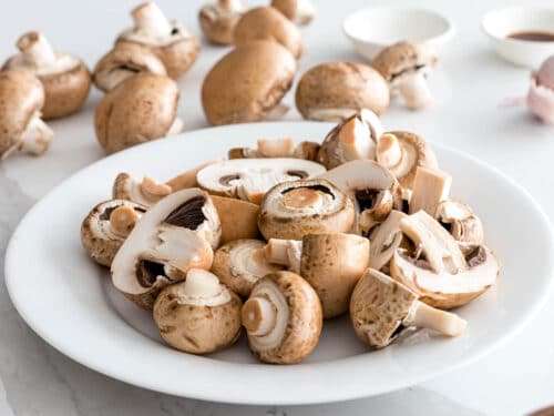 baby portabello mushrooms washed and prepped on a white plate