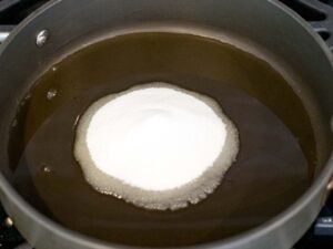 oil and white sugar in a shallow frying pan
