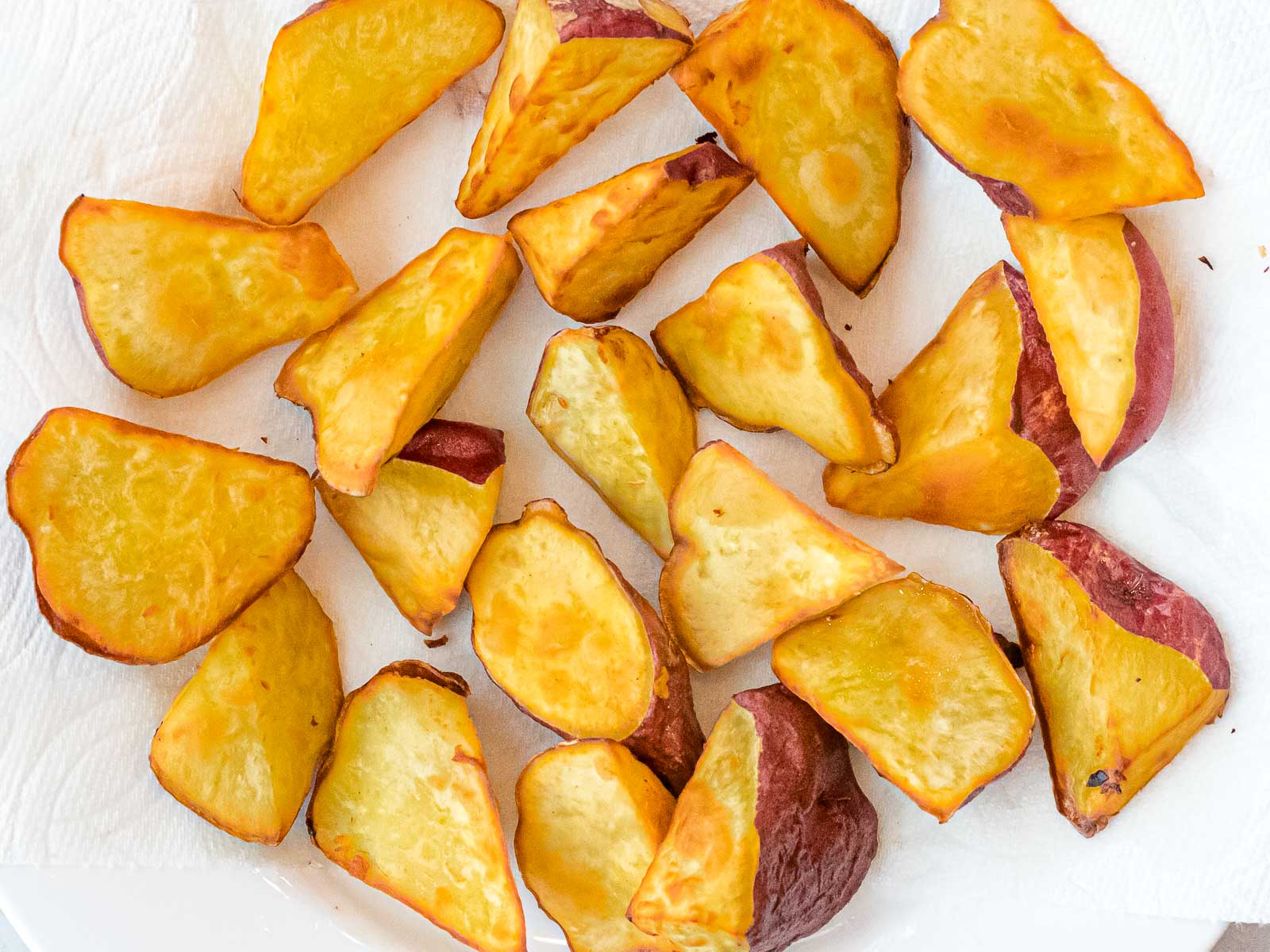 golden brown fried sweet potato pieces on a paper towel