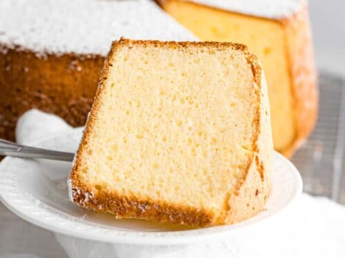 slice of light, fluffy chiffon cake on a white plate with powdered sugar