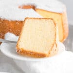 a slice of fluffy chiffon cake on a white plate dusted with powdered sugar