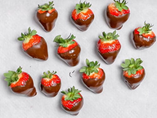 chocolate covered strawberries laying on parchment paper to harden