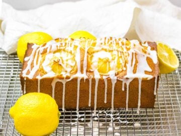 lemon pound cake with glaze dripping down the sides on top of a wire rack