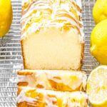lemon pound cake with glaze sliced open next to lemons on a wire rack