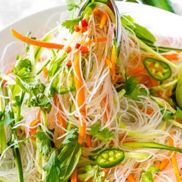 close up of Vietnamese noodle salad with vermicelli rice noodles, carrots, basil, cilantro, and peppers.
