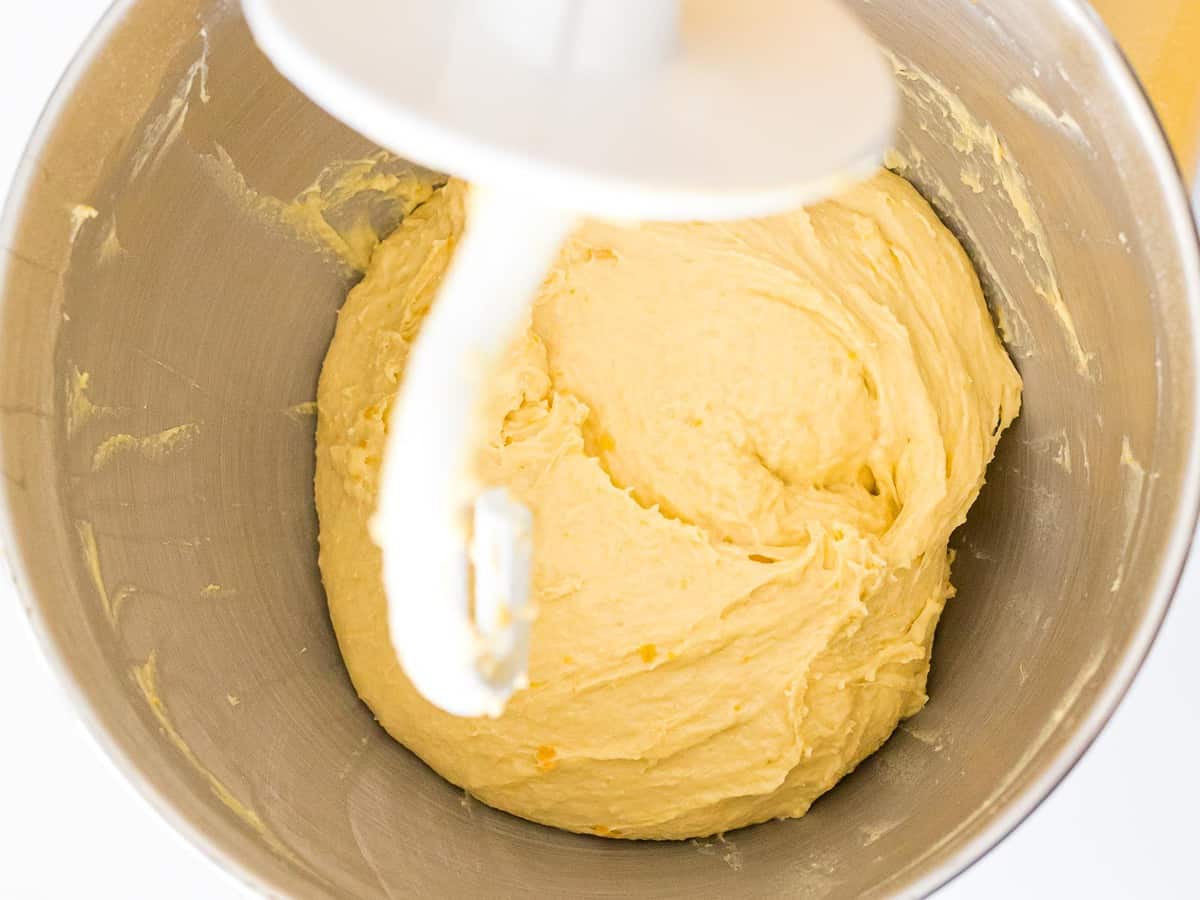 Sourdough pumpkin bread dough in a mixing bowl with a dough hook attachment.