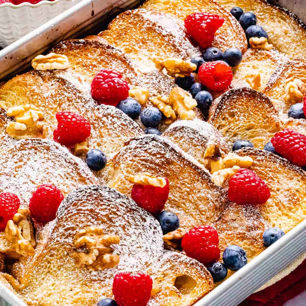 Baked French Toast Casserole with crunchy golden brown crust topped with berries and nuts.