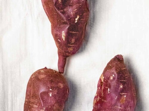 Roasted Korean sweet potatoes (Gungoguma 군고구마) with wrinkled purple skin.