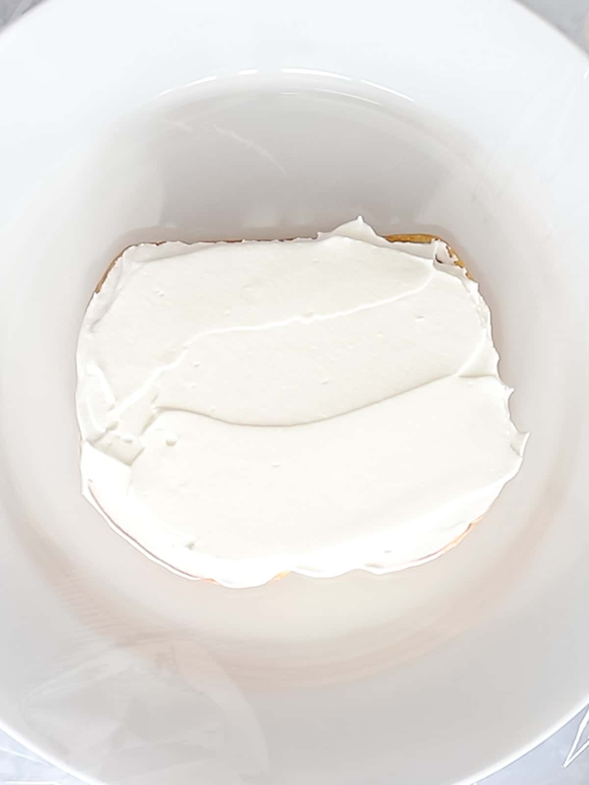 Fluffy whipped cream applied to a slice of white milk bread.