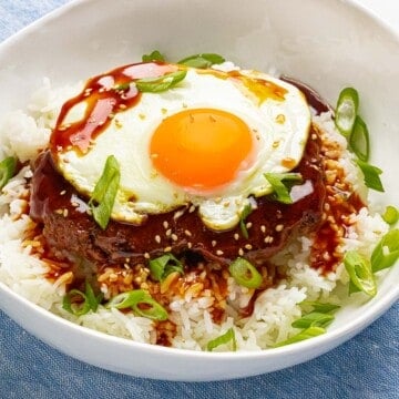 Loco moco made with a juicy beef burger patty on top of rice with brown gravy and a sunny side up egg.