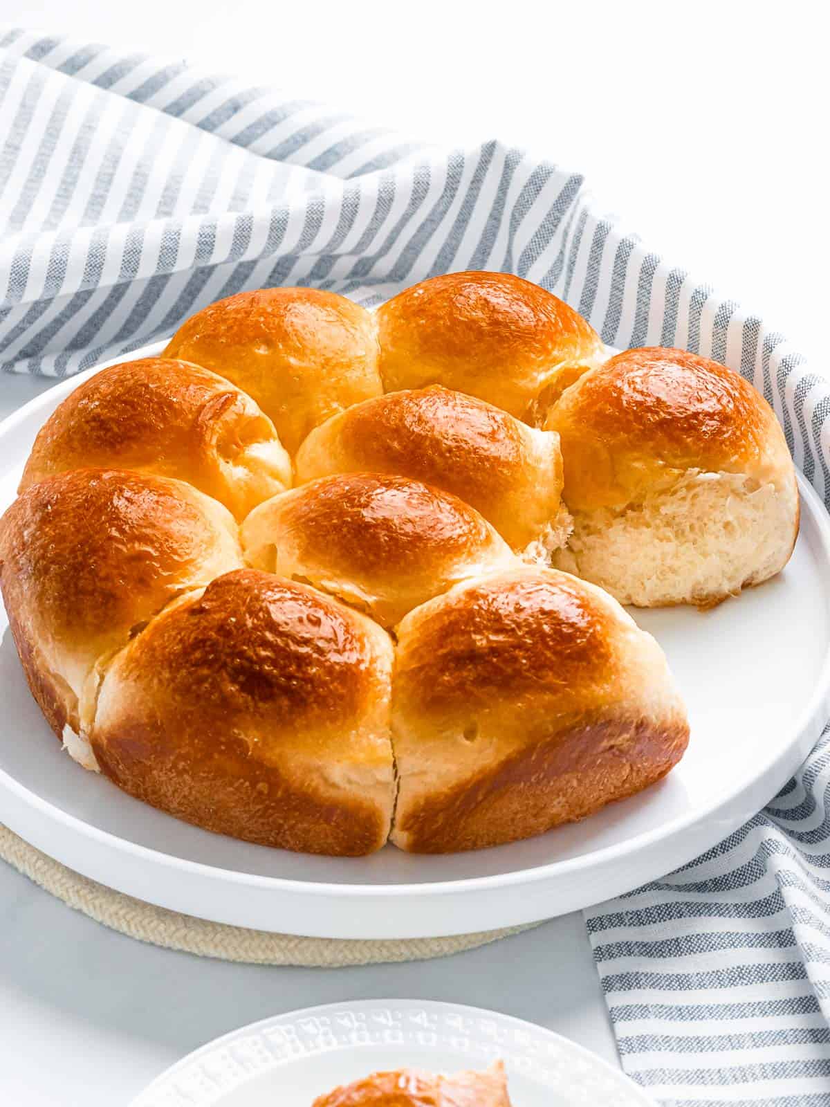 Soft and fluffy brioche rolls with a golden brown crust on a white plate.