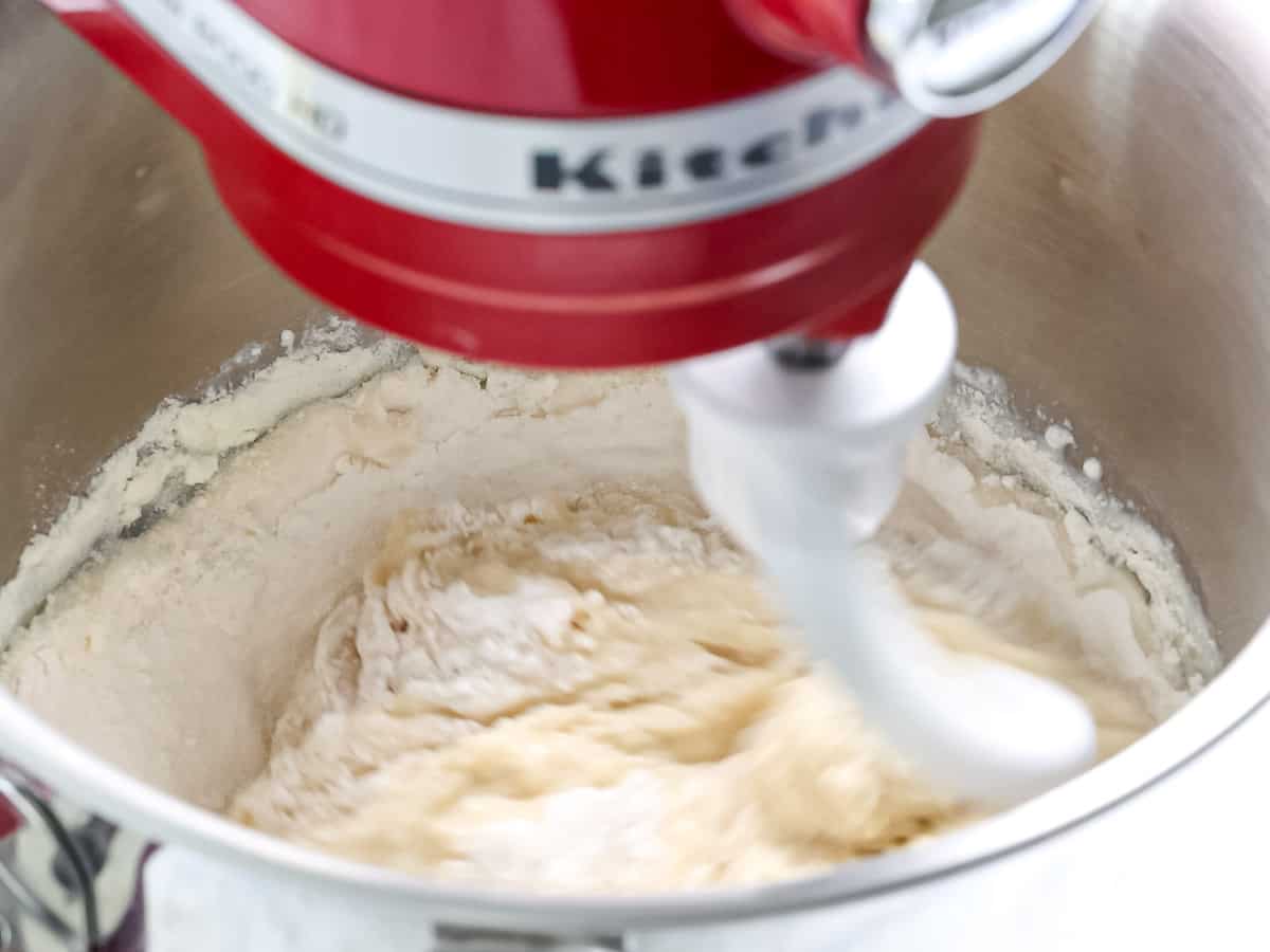 Brioche dough being mixed in a stand mixer.