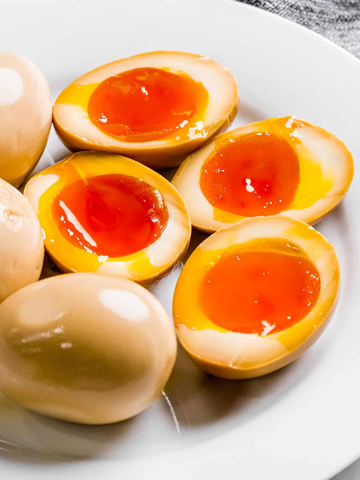 Ramen eggs or soy sauce eggs marinated in a soy mirin mixture that's been cut in half to show jammy yolk.