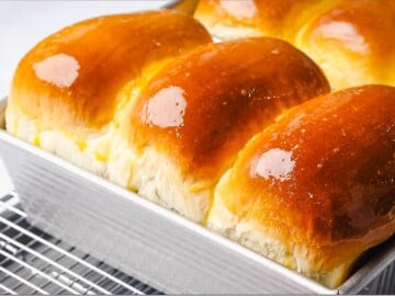 Milk bread loaves baked in the oven with golden brown crust.