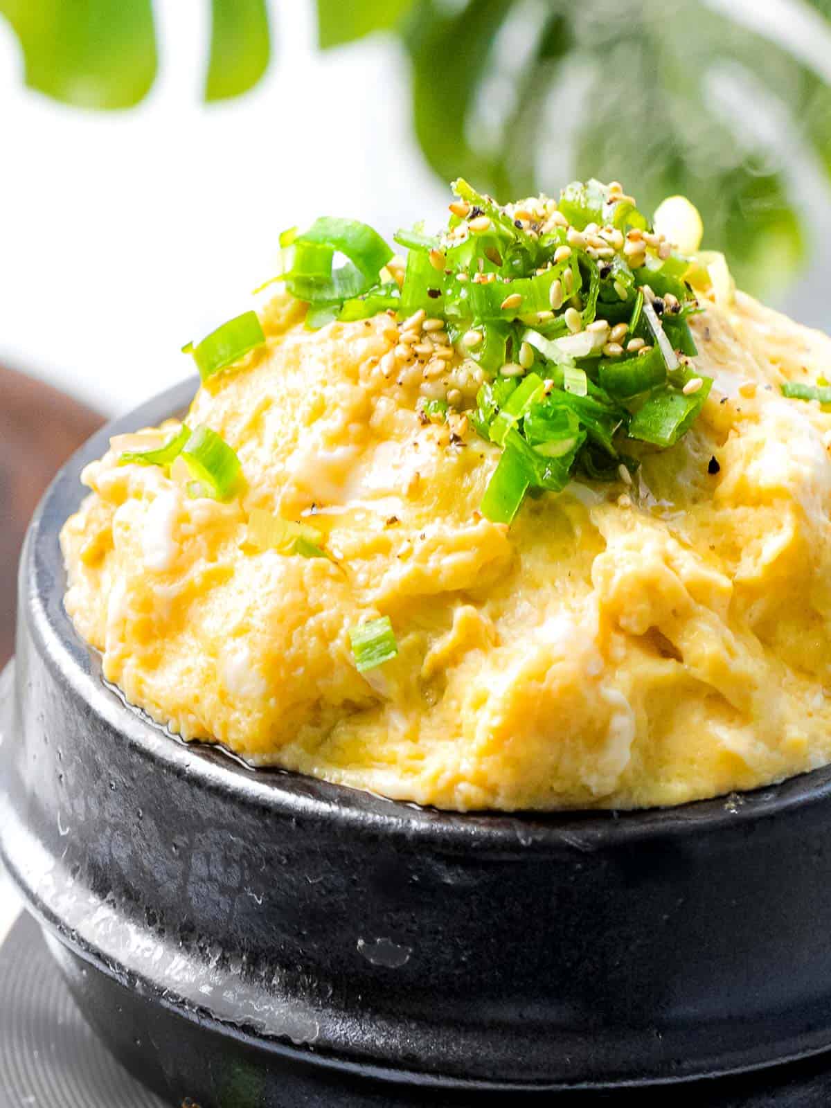 Korean steamed eggs (gyeran jjim) cooked until soft and fluffy and garnished with green onions.