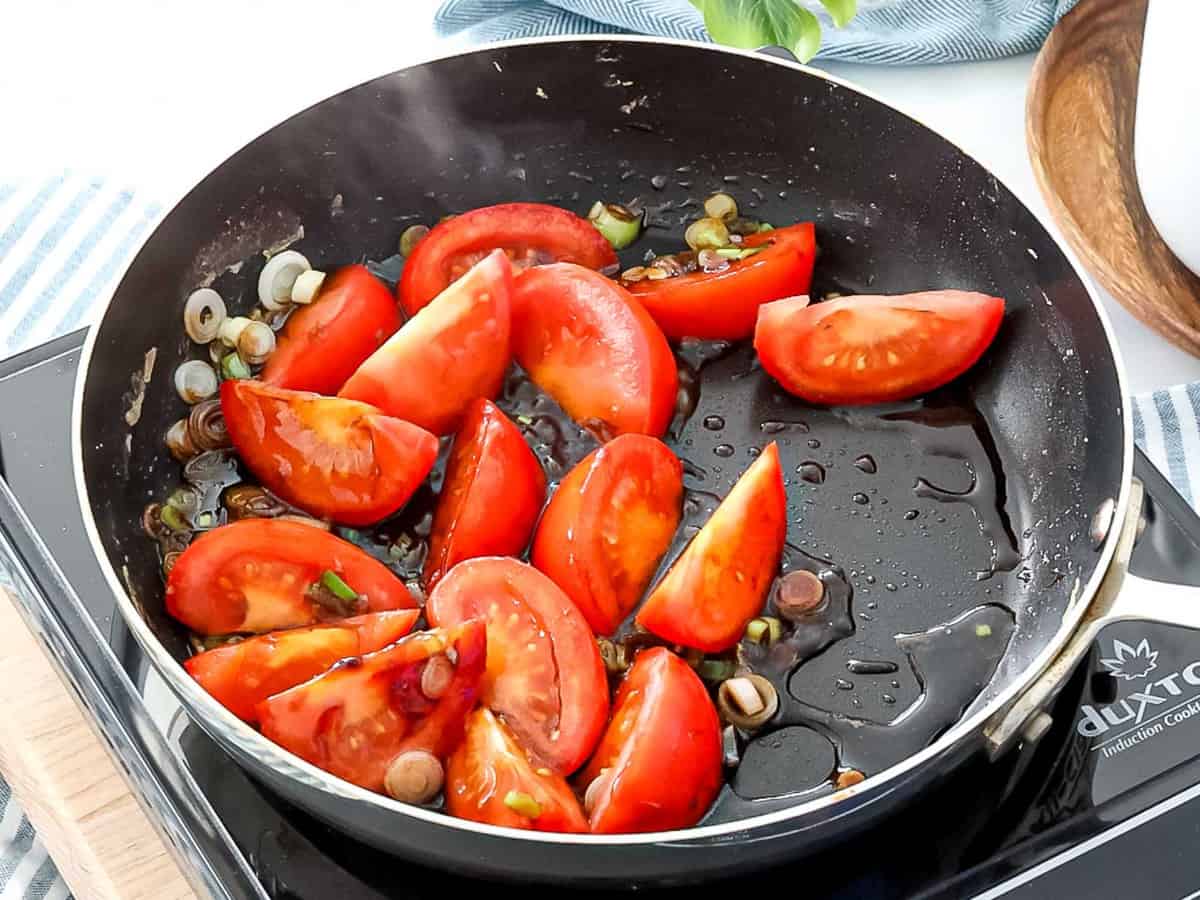 Tomatoes frying in a pan.