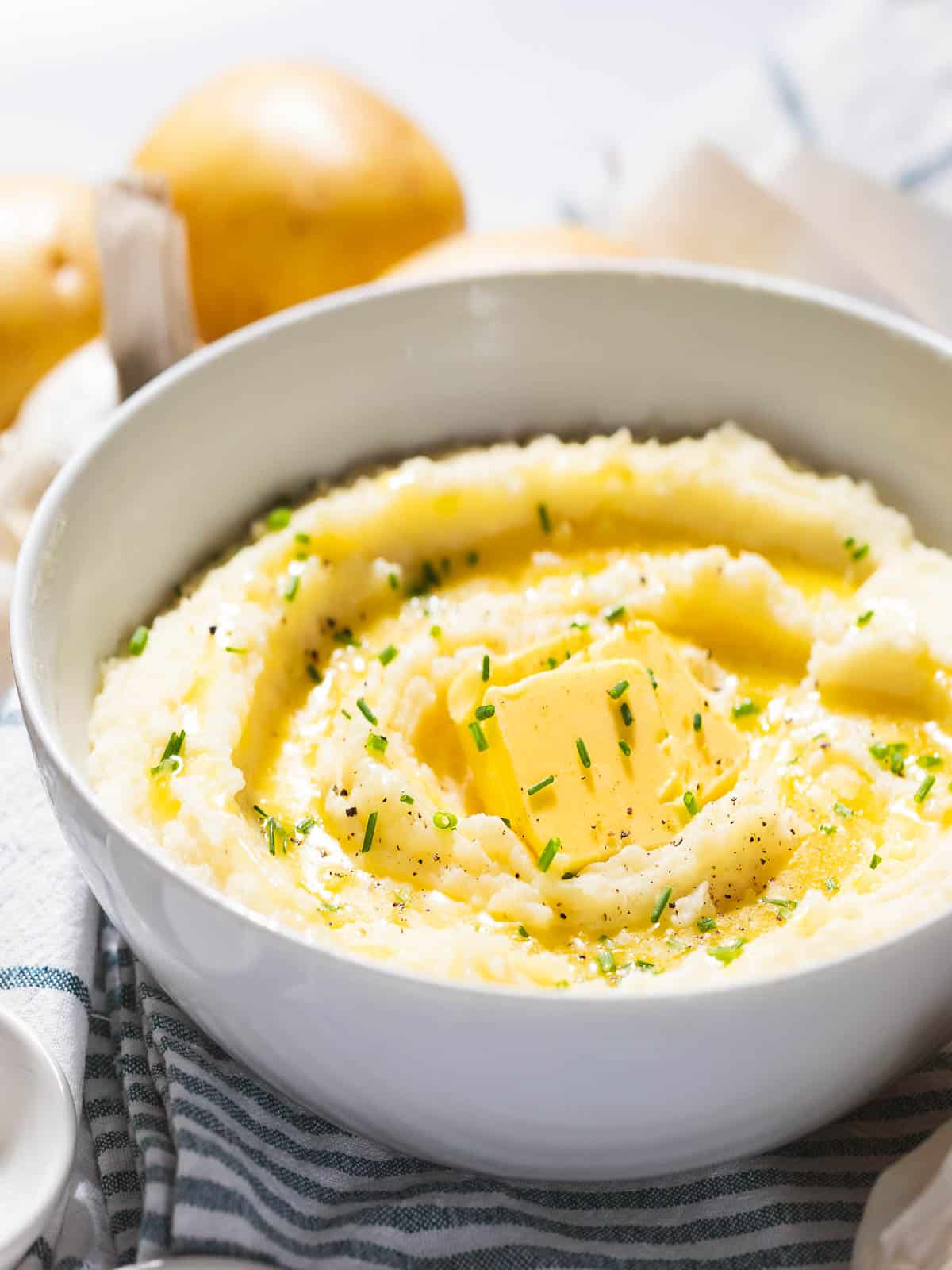 Garlic mashed potatoes with garlic butter in a white bowl.
