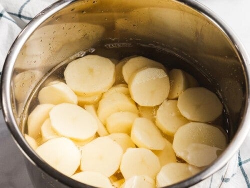 Potato slices in an Instant pot filled with water.