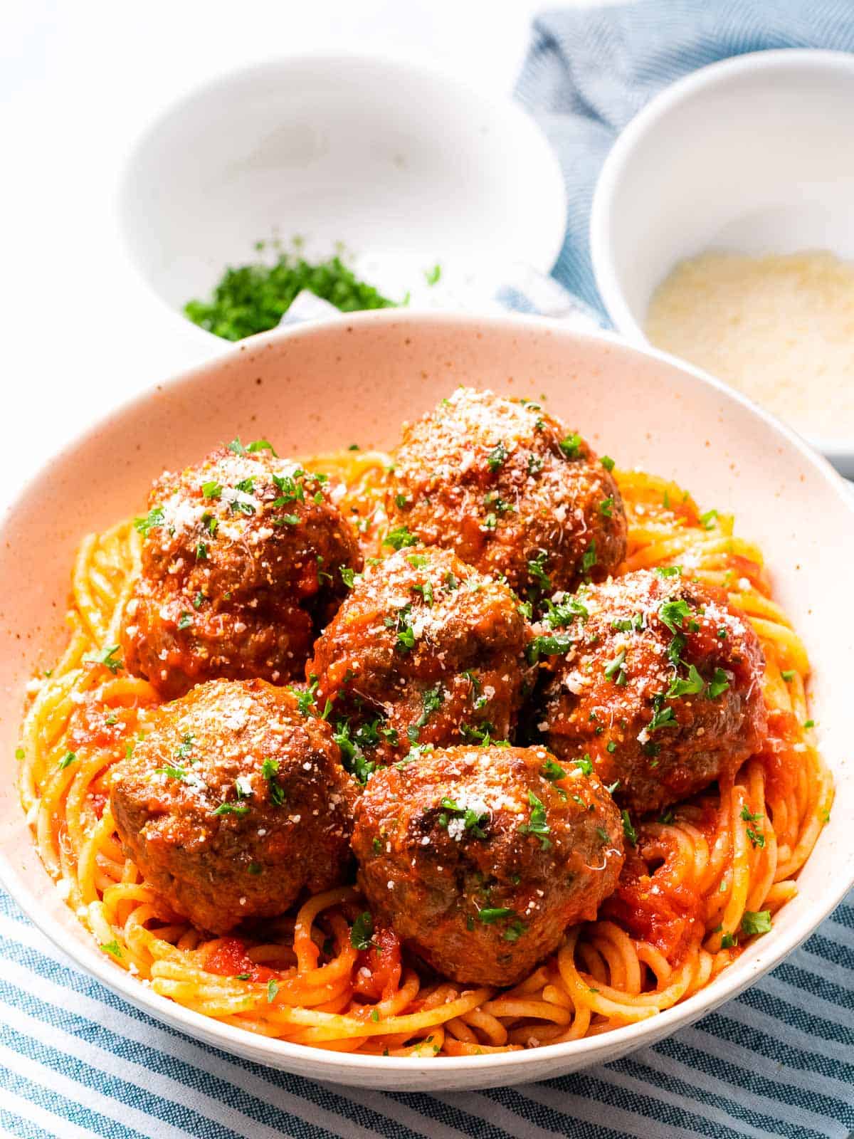 Baked Italian meatballs with parmesan cheese and pasta.