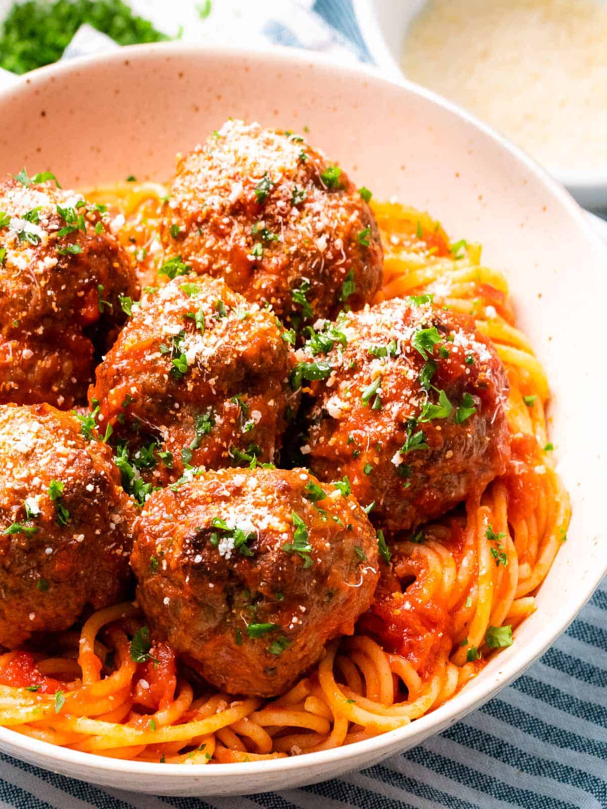 Italian meatballs baked until tender and juicy with a bowl of spaghetti.