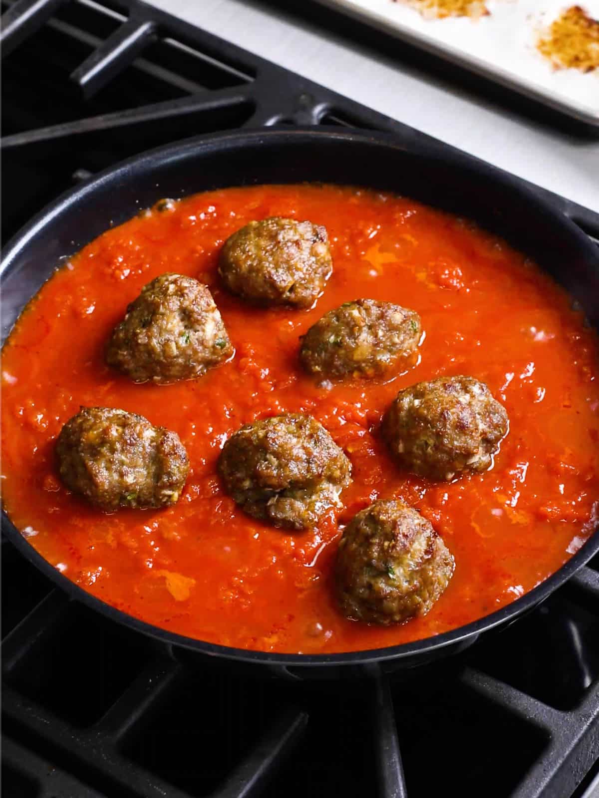 Homemade Italian meatballs simmering in tomato sauce.