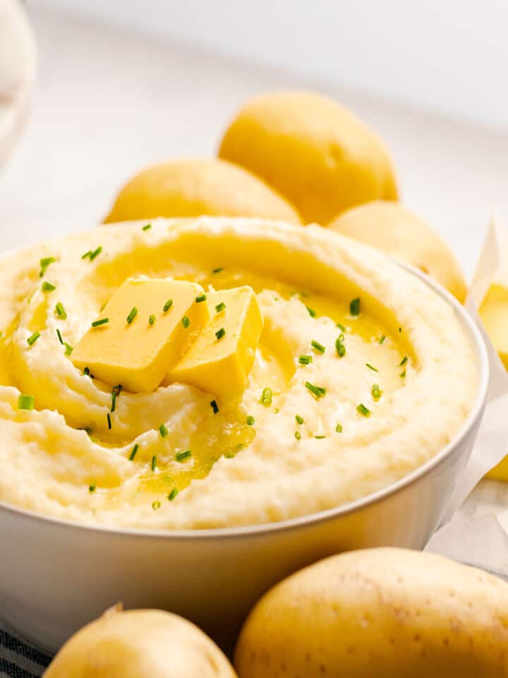 Creamy sour cream mashed potatoes topped with butter and chives.