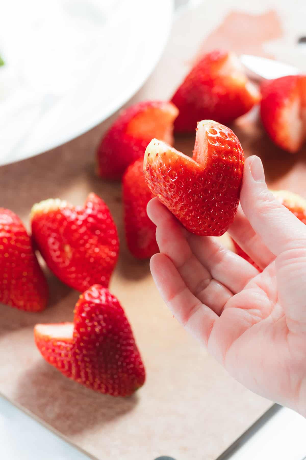 Hand holding strawberry heart.