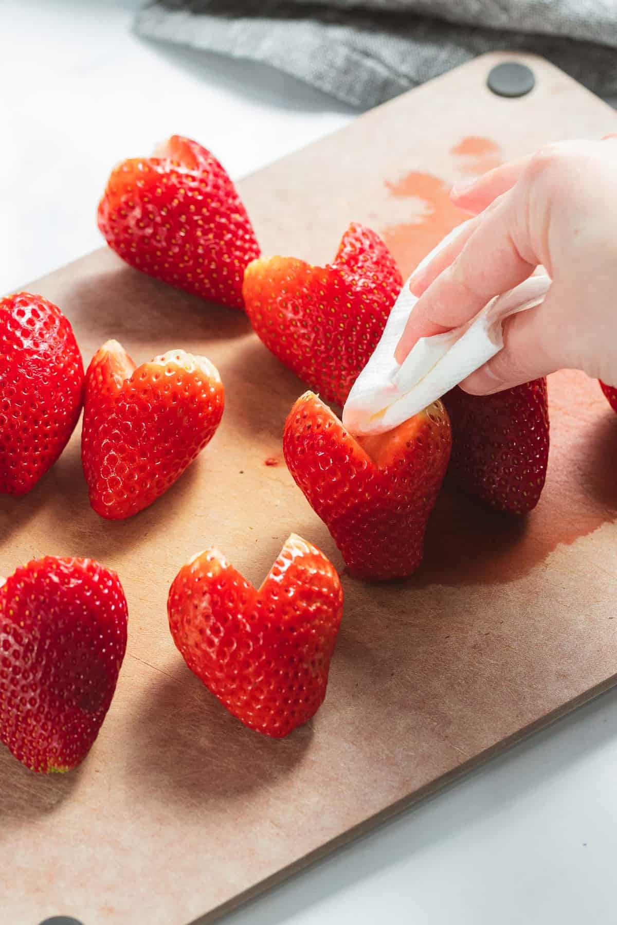 Heart shaped strawberries patted dry with paper towel.