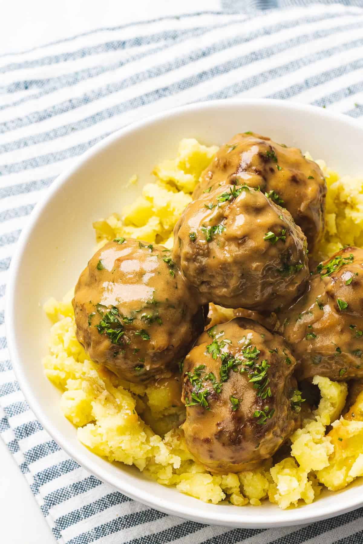 Swedish meatballs with gravy on top of mashed potatoes.