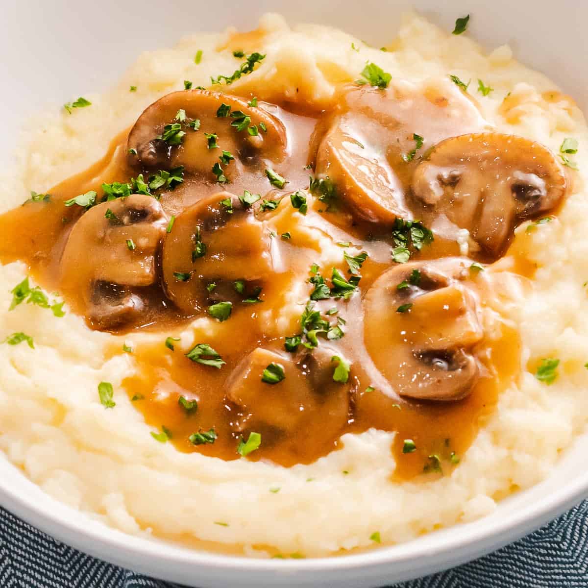 Vegan gravy with mushrooms over mashed potatoes.