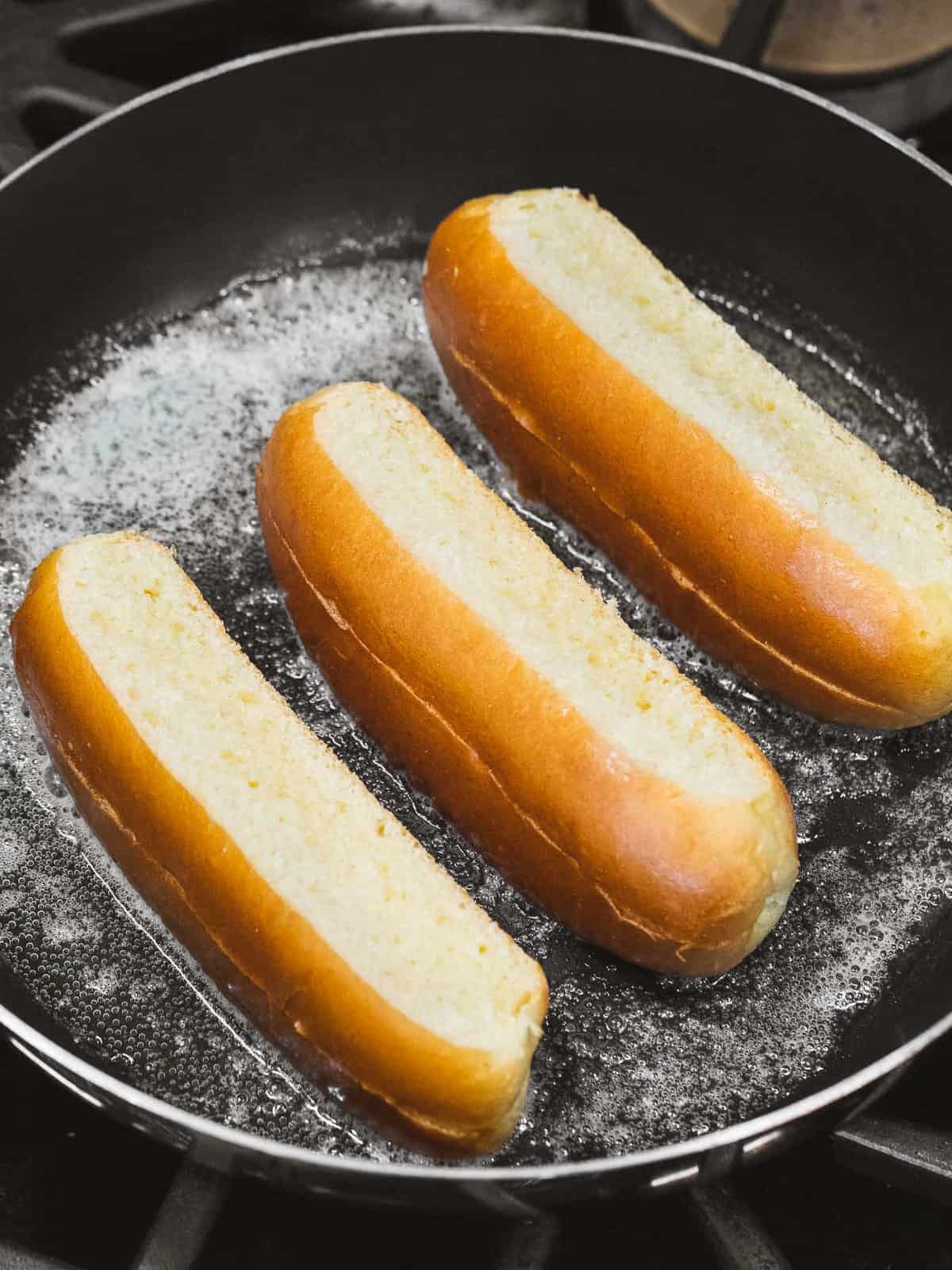 Hot dog buns toasting with melted butter.