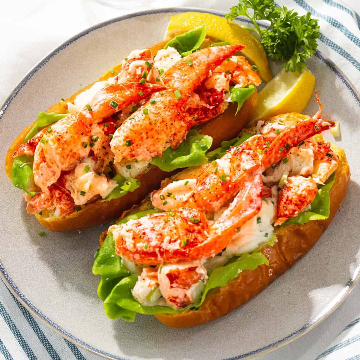 Maine lobster roll with lobster claws dressed in mayo with chives and lettuce.