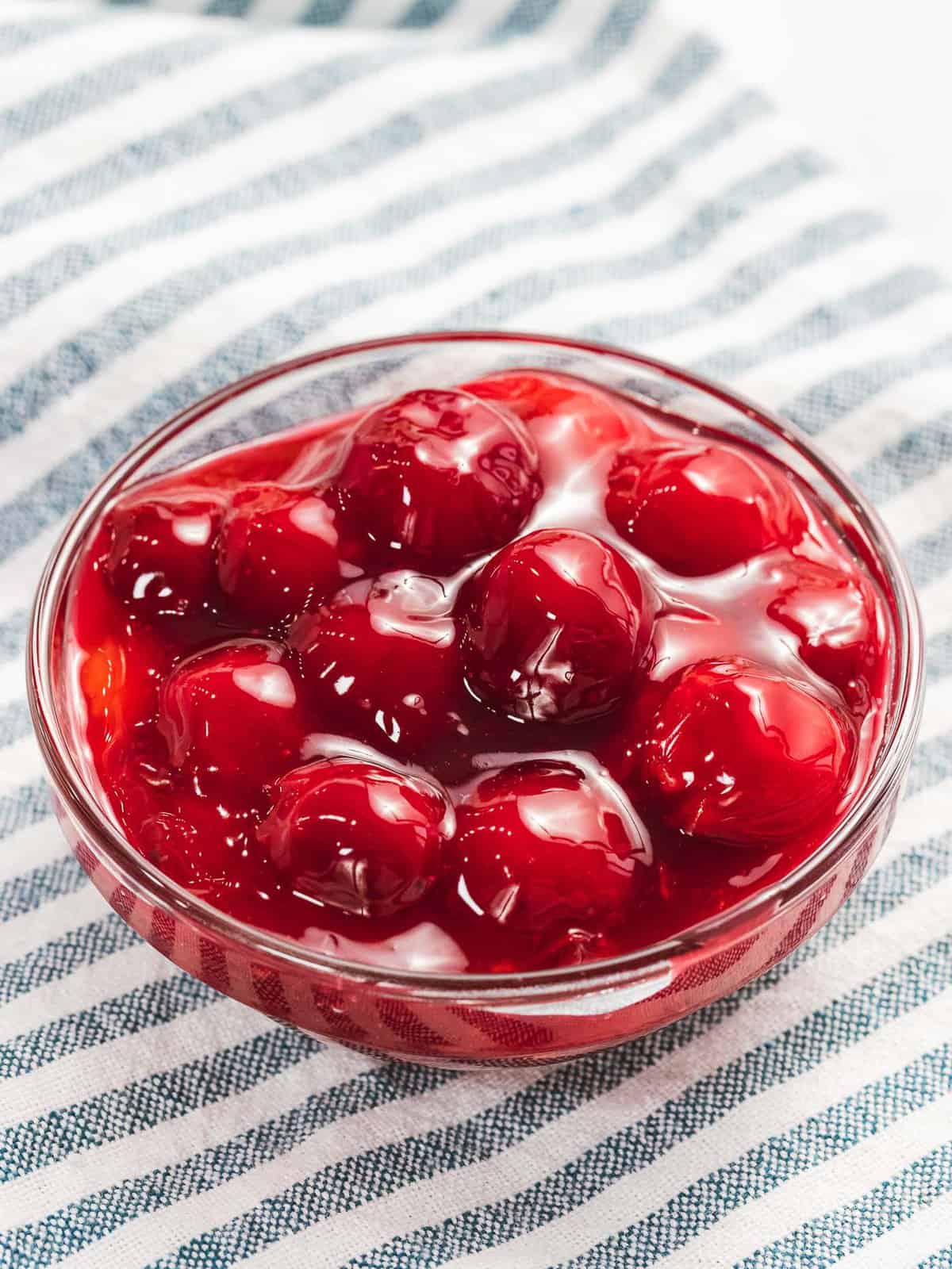 Cherry pie filling with bright red cherries in a bowl.