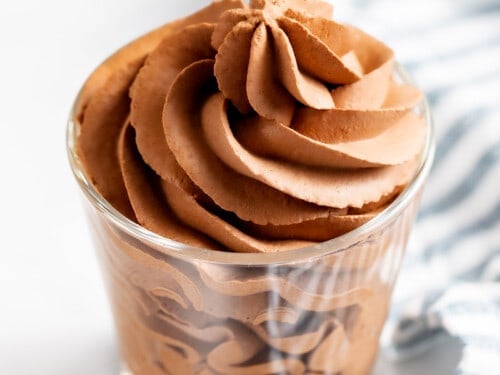 Chocolate whipped cream piped into a glass cup.
