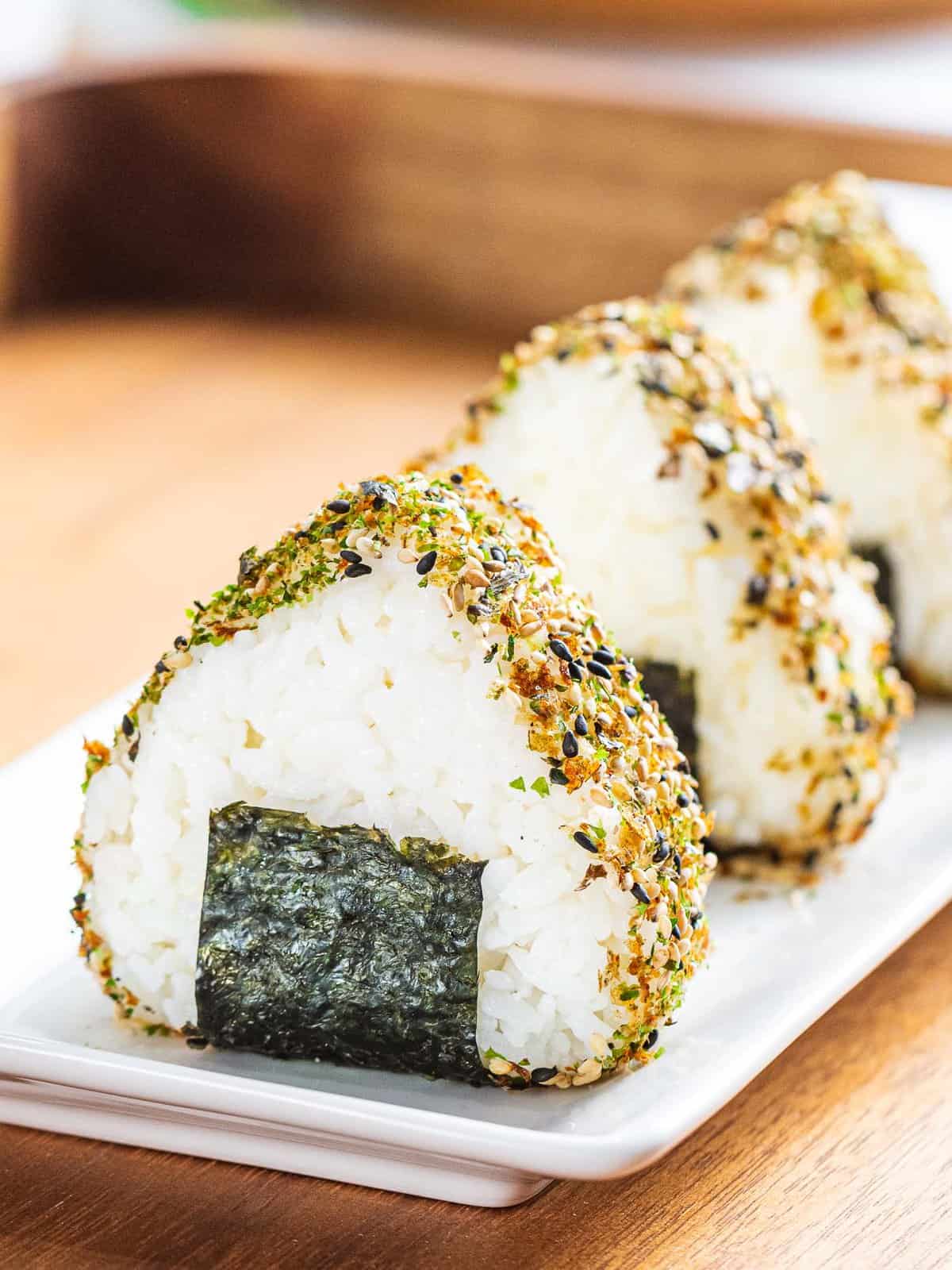 Easy onigiri or Japanese rice balls seasoned with furikake and wrapped with nori seaweed.