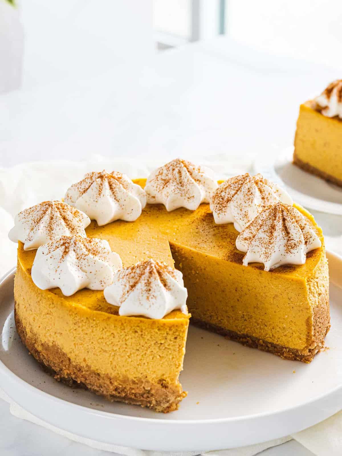 Easy Thanksgiving pumpkin cheesecake with whipped cream.