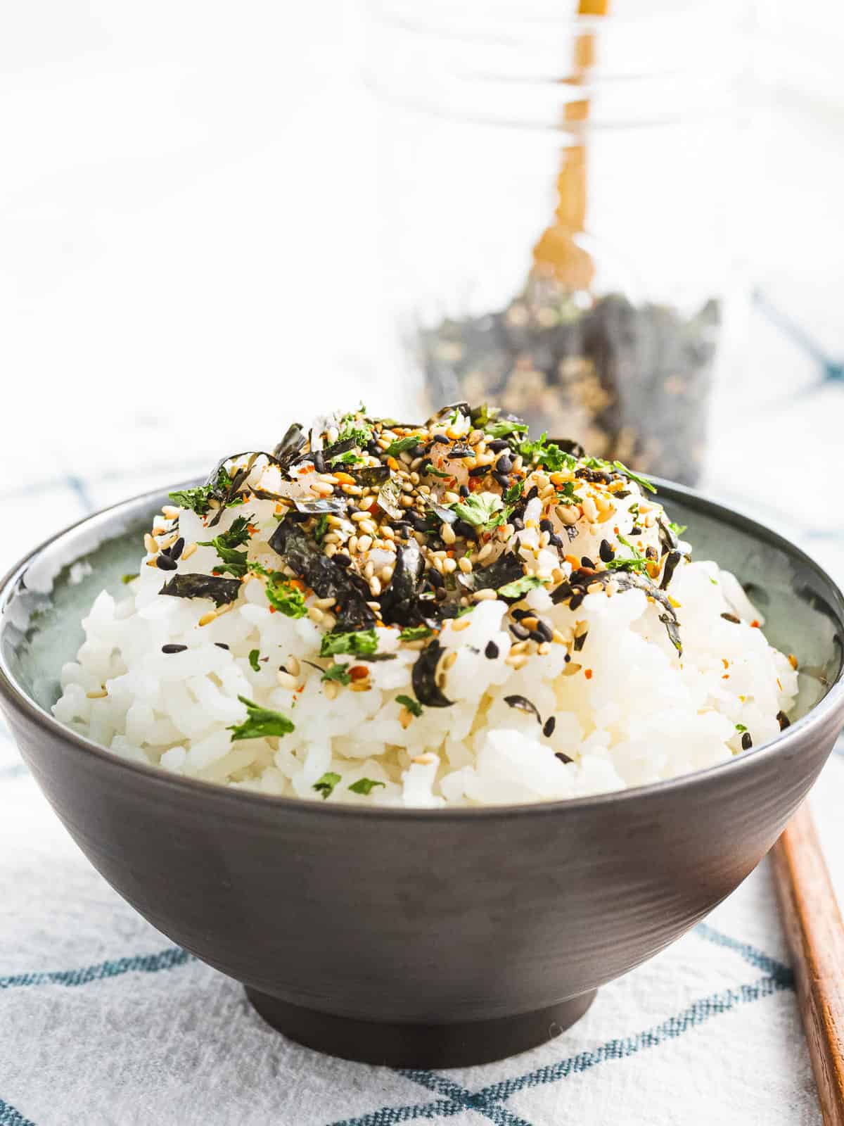 Nori komi furikake with nori and sesame seeds sprinkled on a bowl of steamed rice.