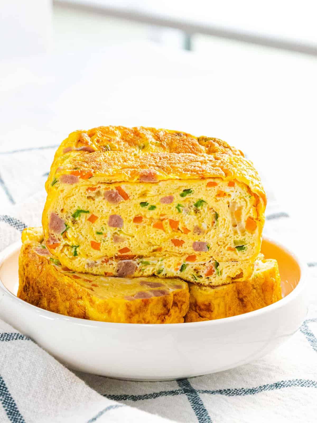 Korean rolled egg omelet or gyeran mari with ham, carrots, and green onions.