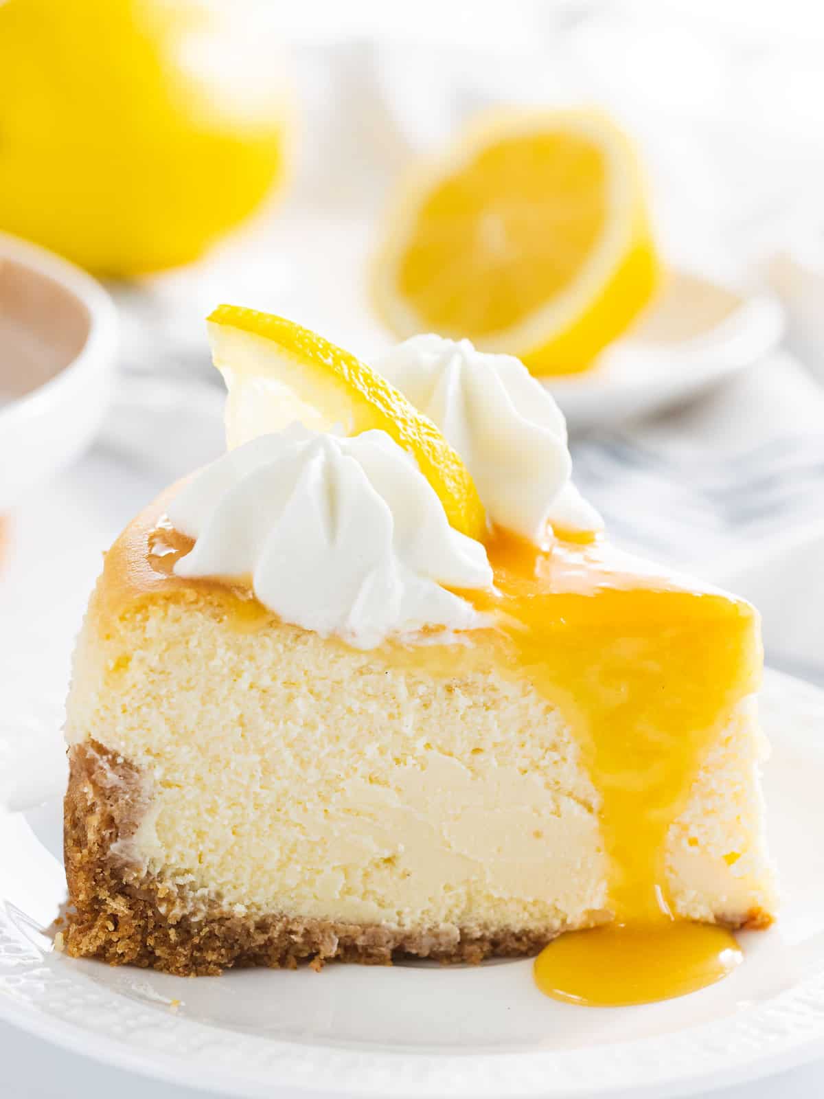 A slice of lemon cheesecake topped with lemon curd and lemon slices.