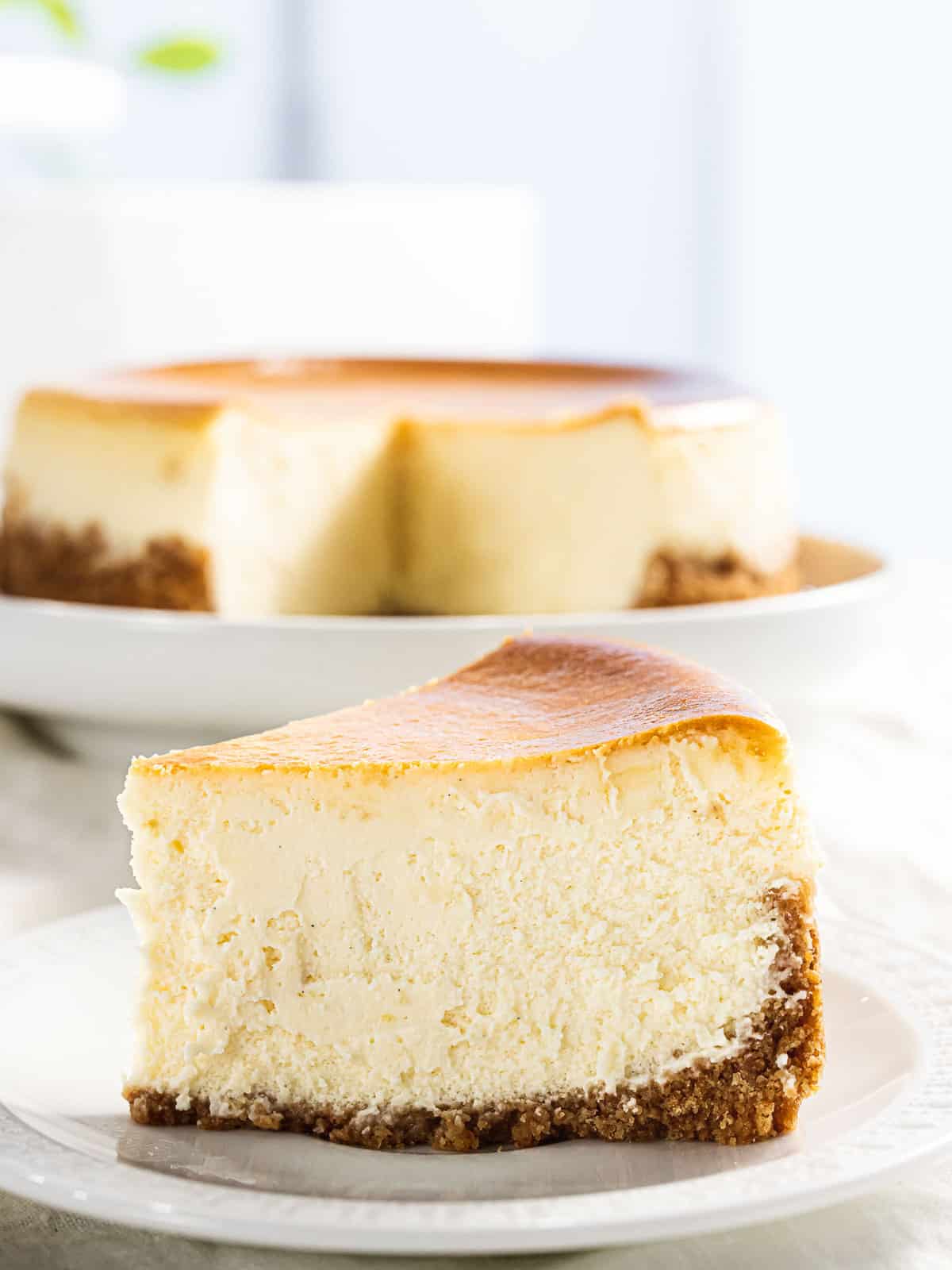 A slice of classic New York-style cheesecake on a plate.