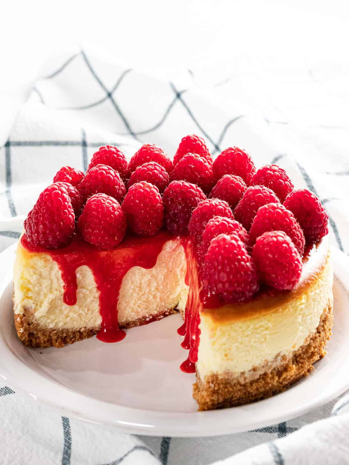Raspberry cheesecake with fresh raspberry topping and sauce.