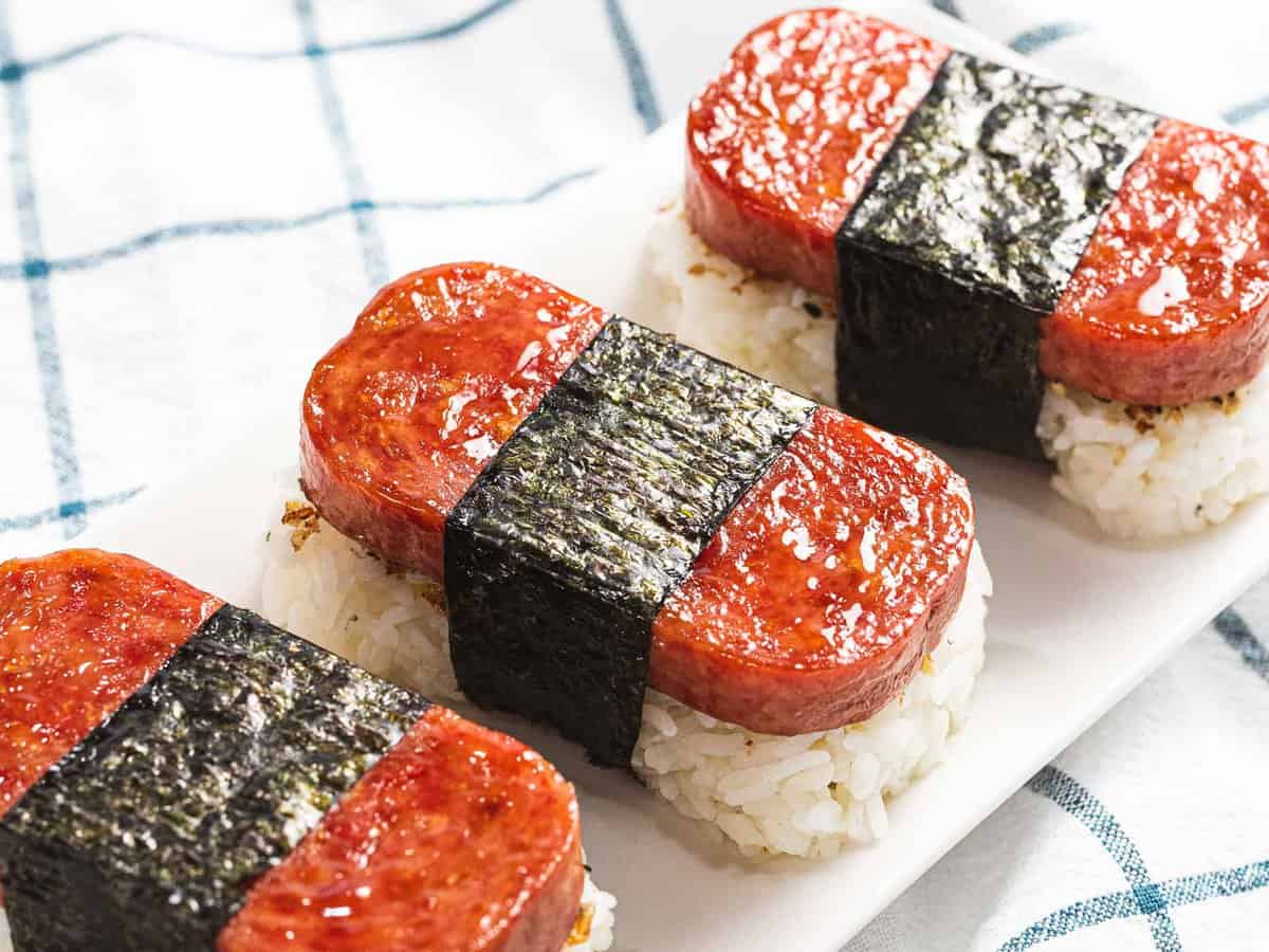 Three pieces of spam musubi glazed with teriyaki sauce.